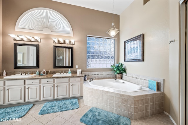 bathroom with tile patterned flooring, a sink, a bath, and double vanity