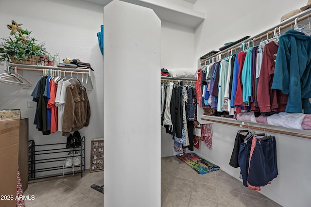 walk in closet with light tile patterned floors