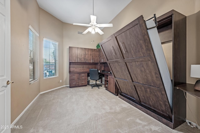 unfurnished office with ceiling fan, visible vents, baseboards, and light colored carpet