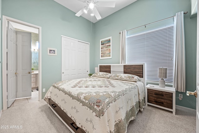 bedroom with ceiling fan, light tile patterned floors, a closet, and light colored carpet