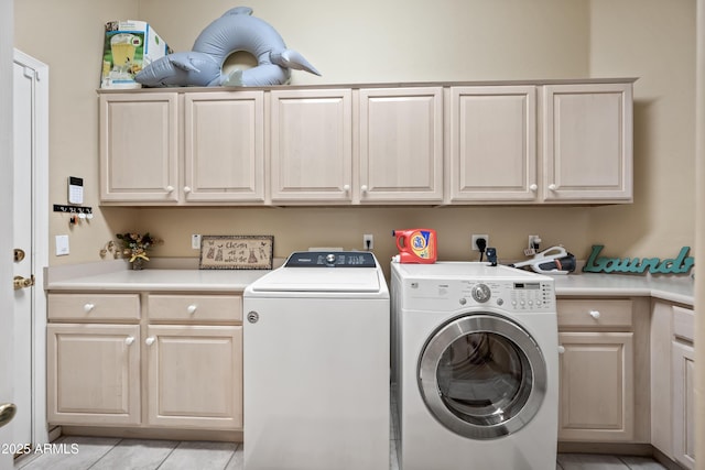 laundry area featuring light tile patterned floors, independent washer and dryer, and cabinet space