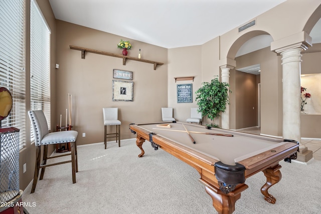 recreation room featuring arched walkways, light carpet, visible vents, baseboards, and decorative columns