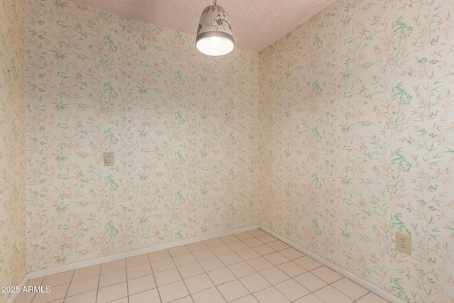 unfurnished room featuring wallpapered walls, baseboards, a textured ceiling, and light tile patterned flooring