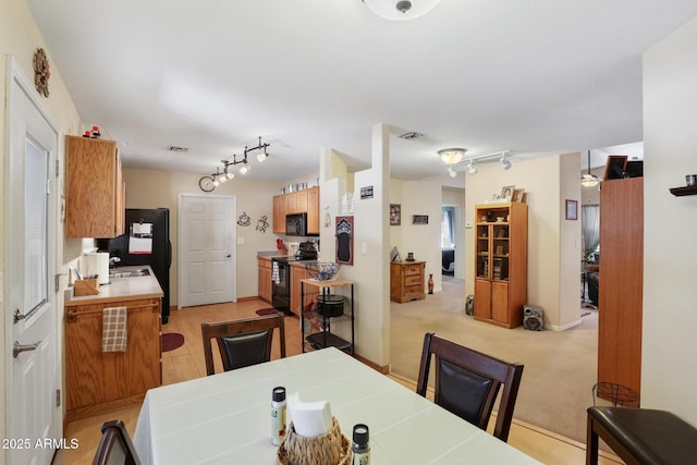 dining area featuring visible vents, light colored carpet, and track lighting