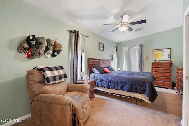 carpeted bedroom featuring lofted ceiling, baseboards, visible vents, and ceiling fan