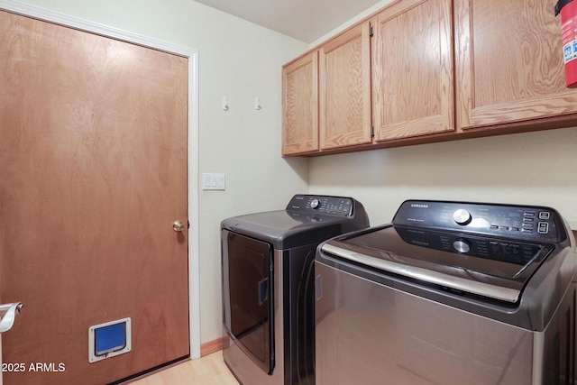 laundry room featuring cabinet space, independent washer and dryer, and light wood-style floors