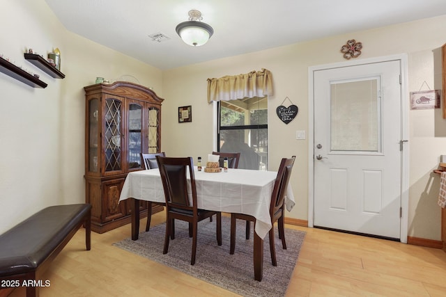 dining area with visible vents, baseboards, and light wood-style flooring