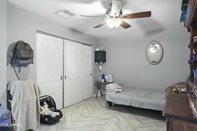 bedroom with ceiling fan, a closet, and light parquet floors