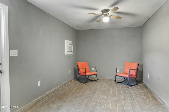 sitting room featuring ceiling fan, light hardwood / wood-style flooring, and a wall mounted air conditioner