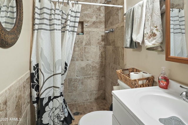 bathroom with a shower with shower curtain, vanity, toilet, and tile walls