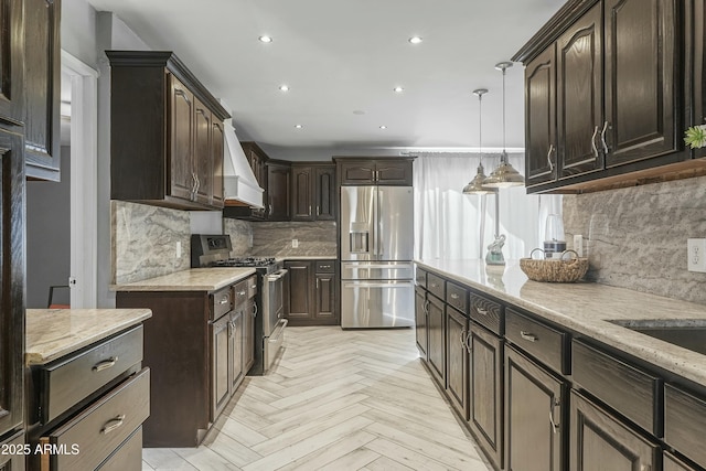 kitchen featuring tasteful backsplash, premium range hood, stainless steel appliances, light parquet floors, and pendant lighting