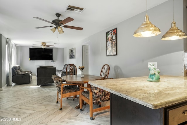 dining space featuring ceiling fan and light parquet flooring