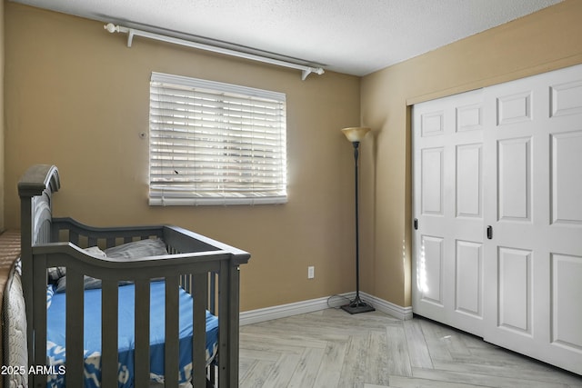 bedroom with a closet, light parquet flooring, and a textured ceiling