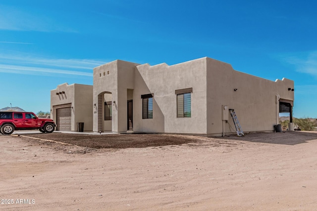 view of front of home with an attached garage and stucco siding