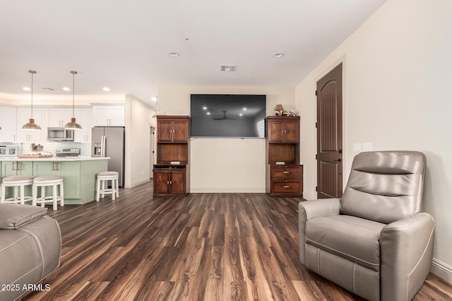 living area featuring baseboards, dark wood-type flooring, visible vents, and recessed lighting