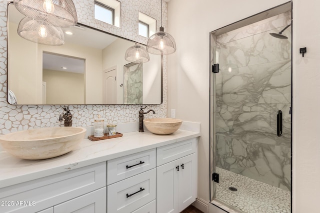 full bath featuring a sink, a marble finish shower, and decorative backsplash