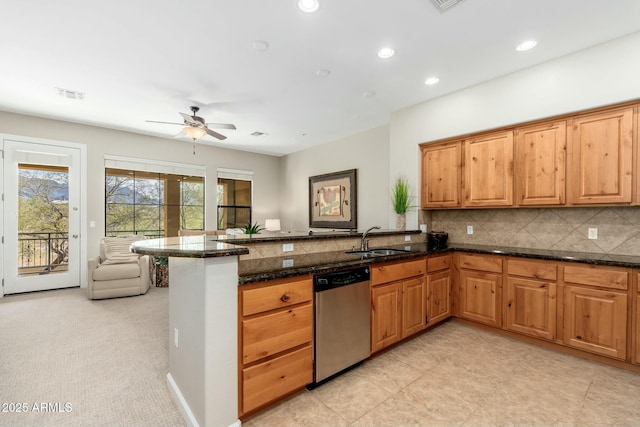 kitchen with a peninsula, a sink, visible vents, stainless steel dishwasher, and tasteful backsplash