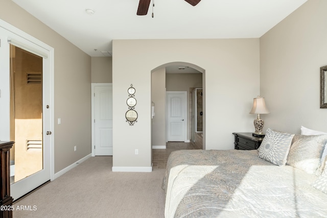 bedroom featuring a ceiling fan, arched walkways, carpet flooring, and baseboards