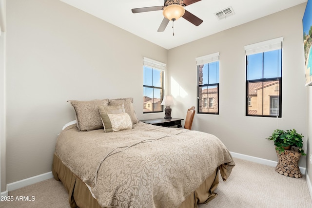 bedroom featuring baseboards, visible vents, and light colored carpet