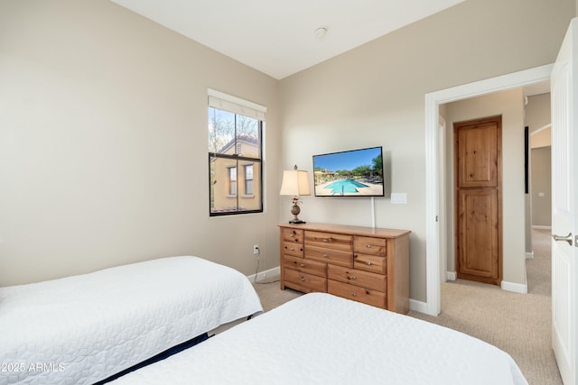 bedroom with light colored carpet and baseboards