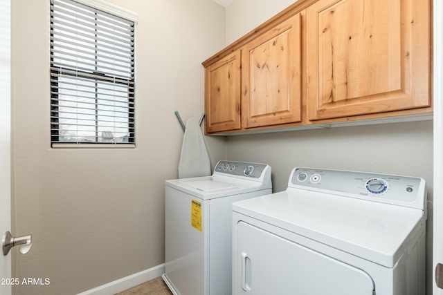 laundry room with cabinet space, baseboards, and separate washer and dryer