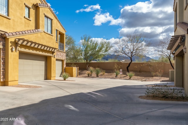 view of patio featuring a garage, driveway, and fence