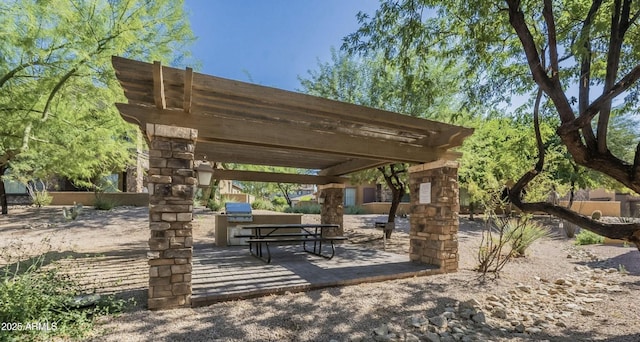 view of property's community with an outdoor kitchen, a pergola, and a patio