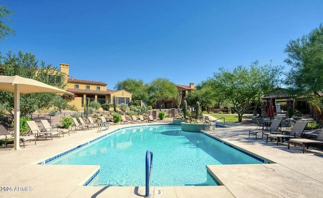 community pool with a pergola, fence, and a patio