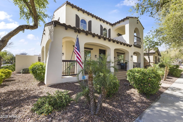 mediterranean / spanish home featuring stucco siding and a porch