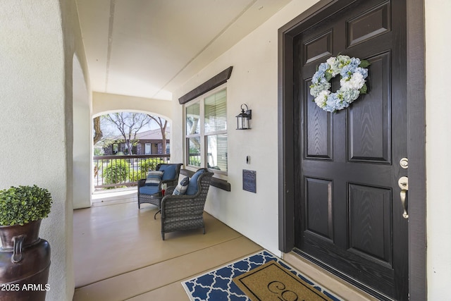 entrance to property featuring stucco siding and a porch