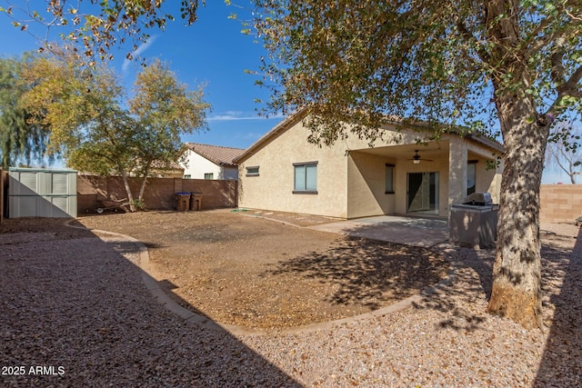 back of house with a storage shed, ceiling fan, and a patio area