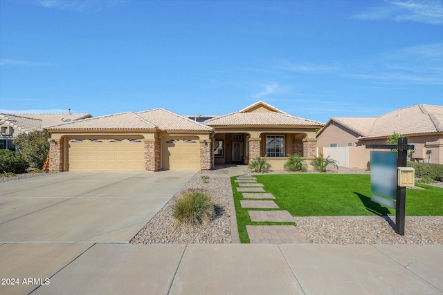 ranch-style house featuring a garage and a front lawn