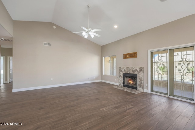 unfurnished living room featuring dark wood-type flooring, a wealth of natural light, ceiling fan, and a fireplace