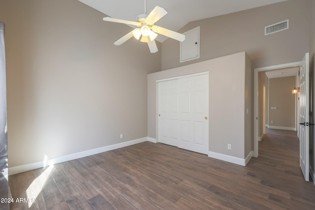 unfurnished bedroom featuring high vaulted ceiling, dark wood-type flooring, ceiling fan, and a closet