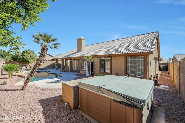 back of property with a patio and a pool with hot tub