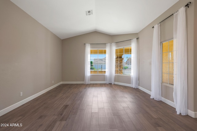 empty room featuring dark hardwood / wood-style flooring, lofted ceiling, and a healthy amount of sunlight