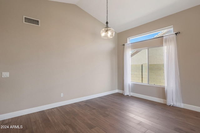 empty room featuring a chandelier, vaulted ceiling, and dark hardwood / wood-style floors