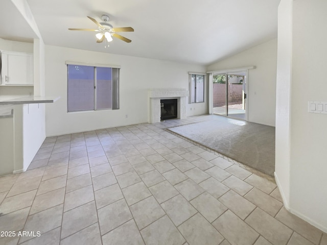 unfurnished living room featuring ceiling fan, light tile patterned flooring, lofted ceiling, and a fireplace