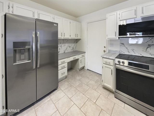 kitchen with light tile patterned floors, white cabinetry, backsplash, and appliances with stainless steel finishes