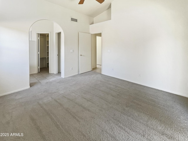 spare room featuring light colored carpet, high vaulted ceiling, and ceiling fan