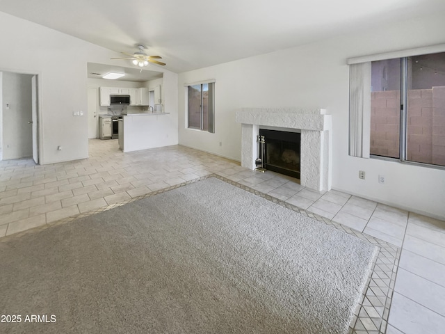 unfurnished living room with ceiling fan, light tile patterned floors, and a premium fireplace