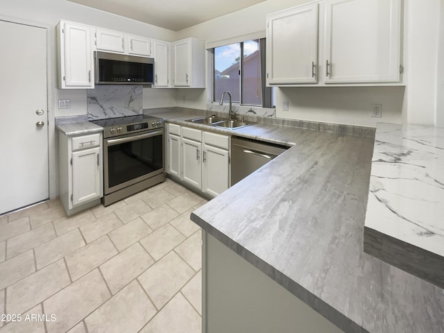 kitchen with white cabinets, appliances with stainless steel finishes, backsplash, and sink