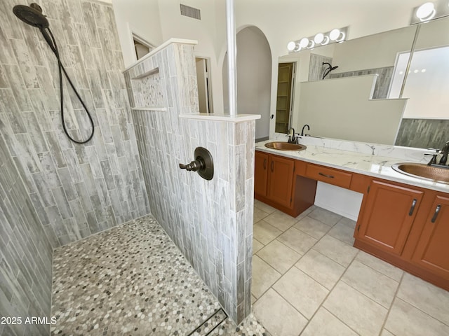 bathroom featuring tiled shower, vanity, and tile patterned floors