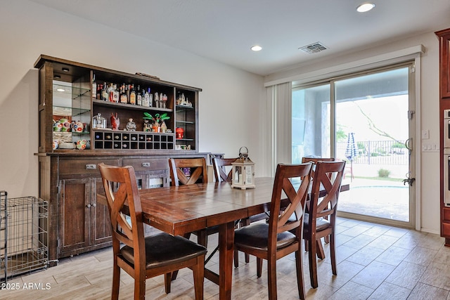 dining area with light wood-style flooring, visible vents, and recessed lighting