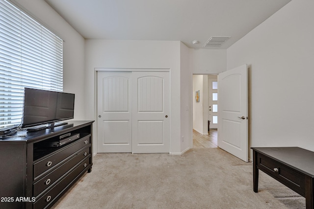 unfurnished bedroom with a closet, visible vents, and light colored carpet