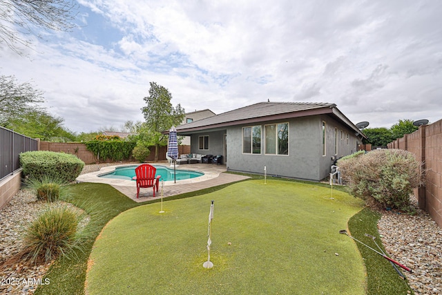 back of property with a patio, stucco siding, a fenced backyard, an outdoor hangout area, and a fenced in pool