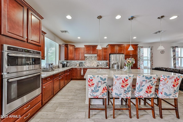 kitchen with a wealth of natural light, stainless steel appliances, visible vents, and recessed lighting