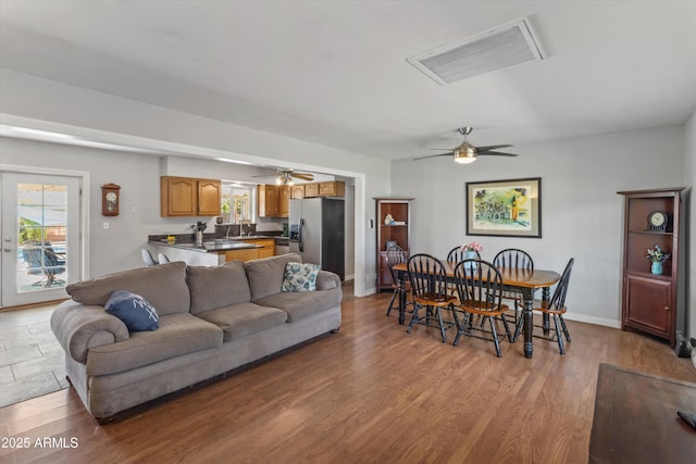 living room featuring wood finished floors, visible vents, and ceiling fan