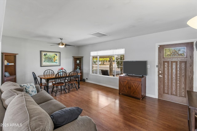 living room featuring baseboards, ceiling fan, and dark wood-style flooring