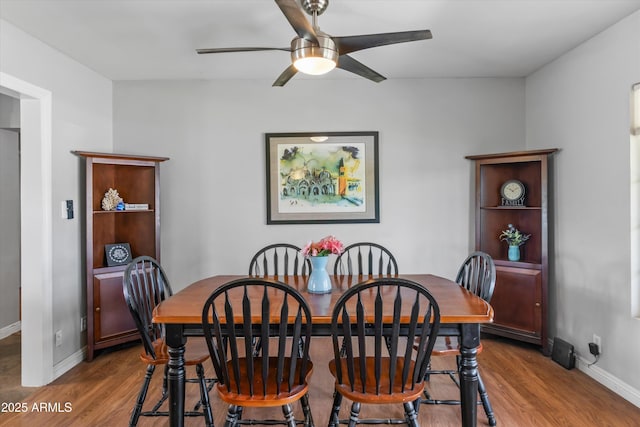 dining space featuring ceiling fan, baseboards, and wood finished floors